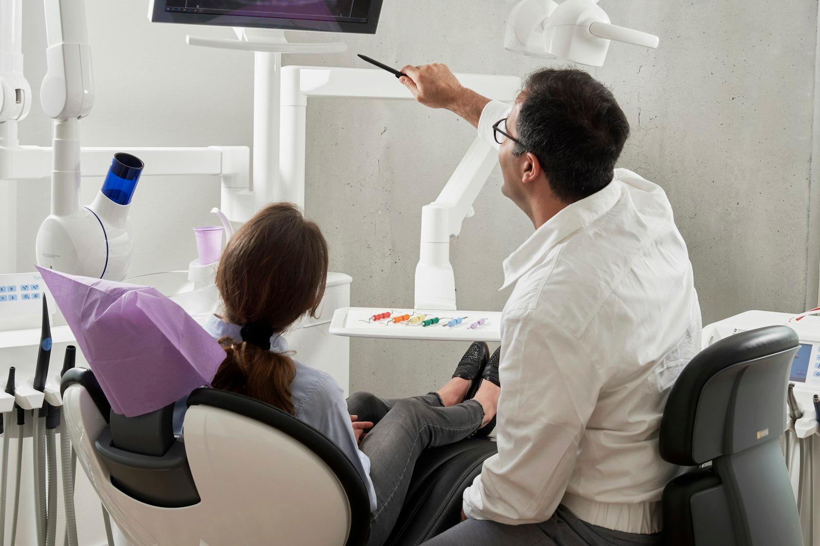 Dentist and assistant treating a patient in an operatory