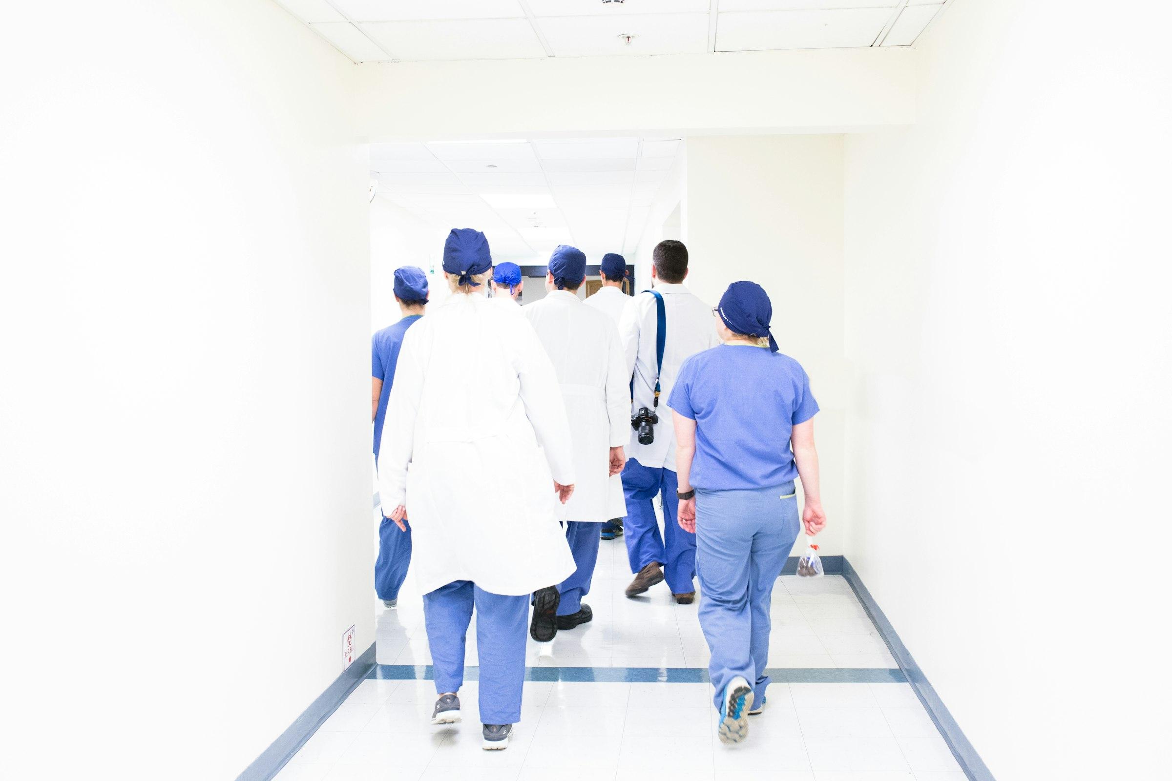 Clinical staff walking through a hospital corridor